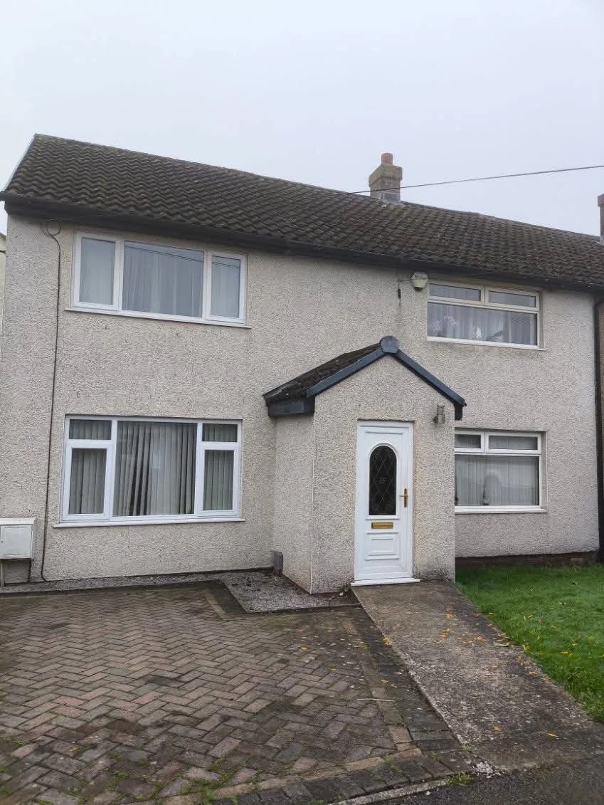 Traditional Lancashire semi-detached house with a pitched tiled roof and pebble-dash rendering
