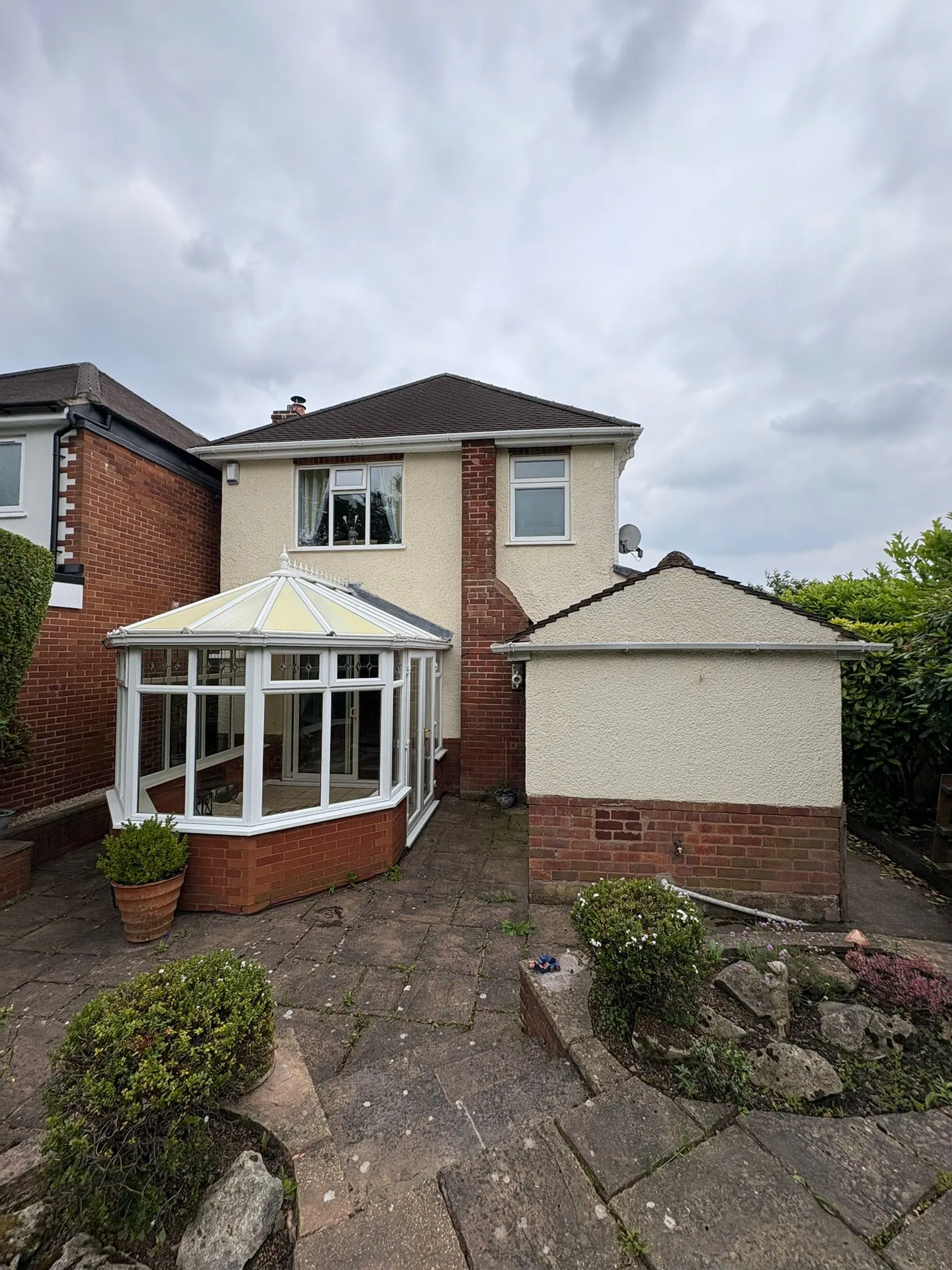 Rear of a house with an old conservatory and a single-storey side extension, illustrating a property ready for modernisation or expansion.