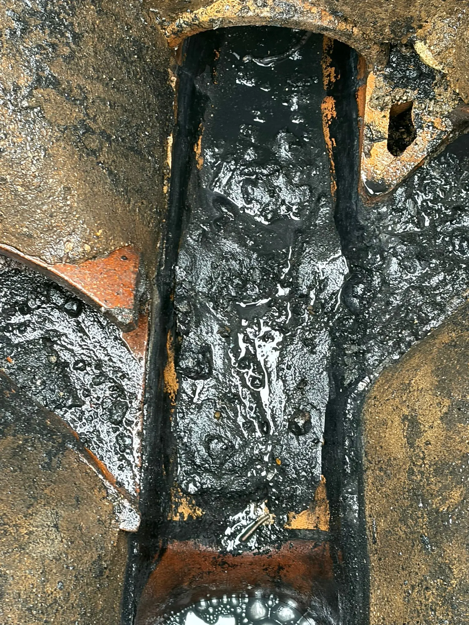 Severe grease and sludge blockage in an outdoor drain chamber requiring professional unblocking in Slough.