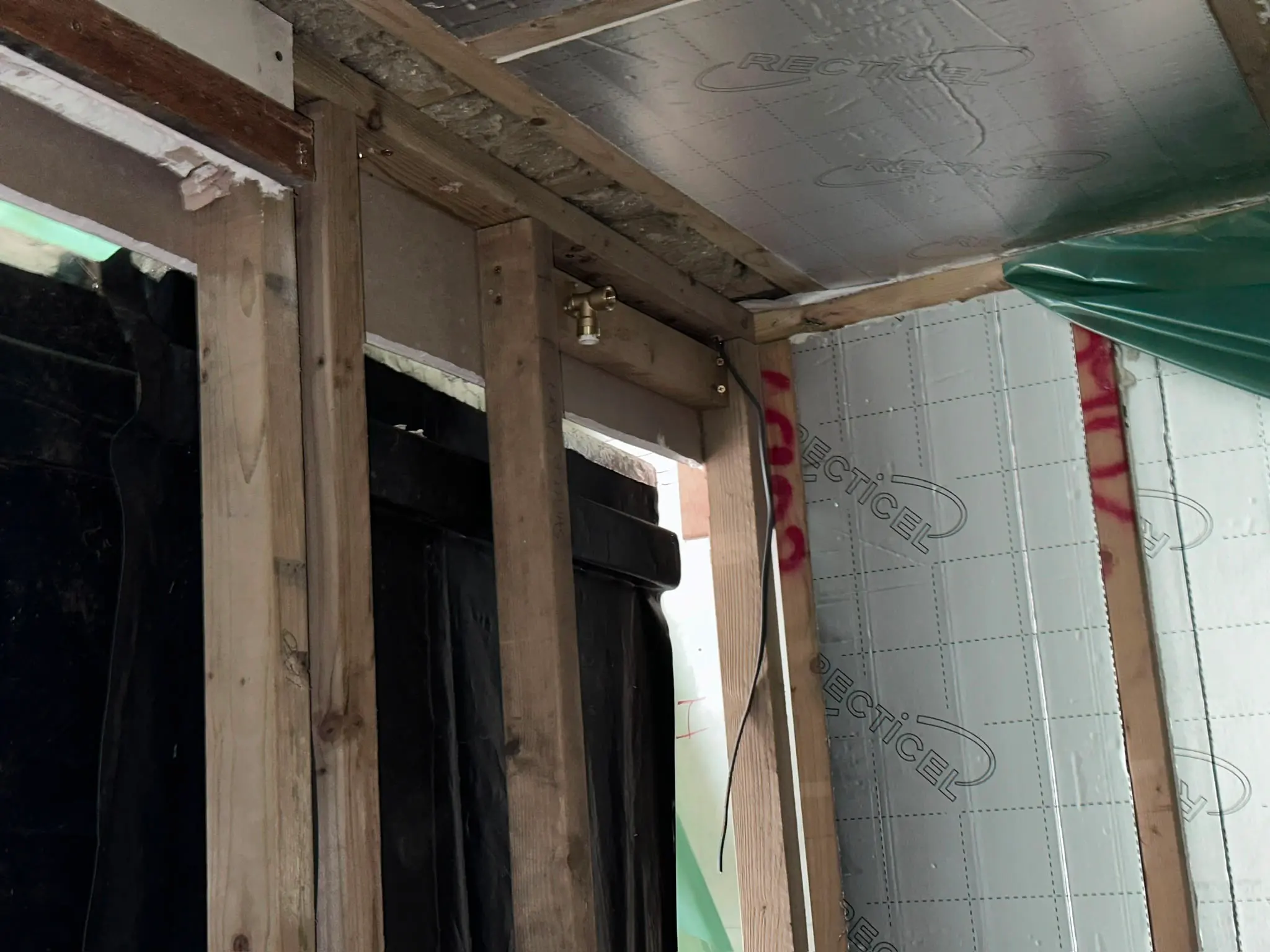Plumbing fixture attached to wooden studs during bathroom renovation
