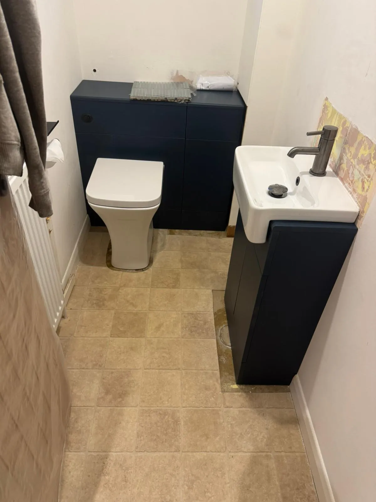 Modern bathroom installation in Felixstowe by FLEX PROPERTY SERVICES showing navy blue furniture and white fixtures.