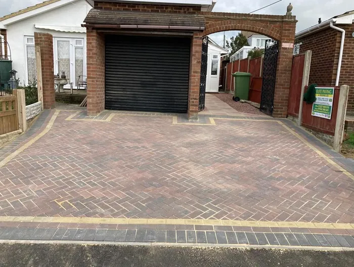 A completed block paving driveway project at a residential home, featuring a herringbone pattern and decorative block paving borders.