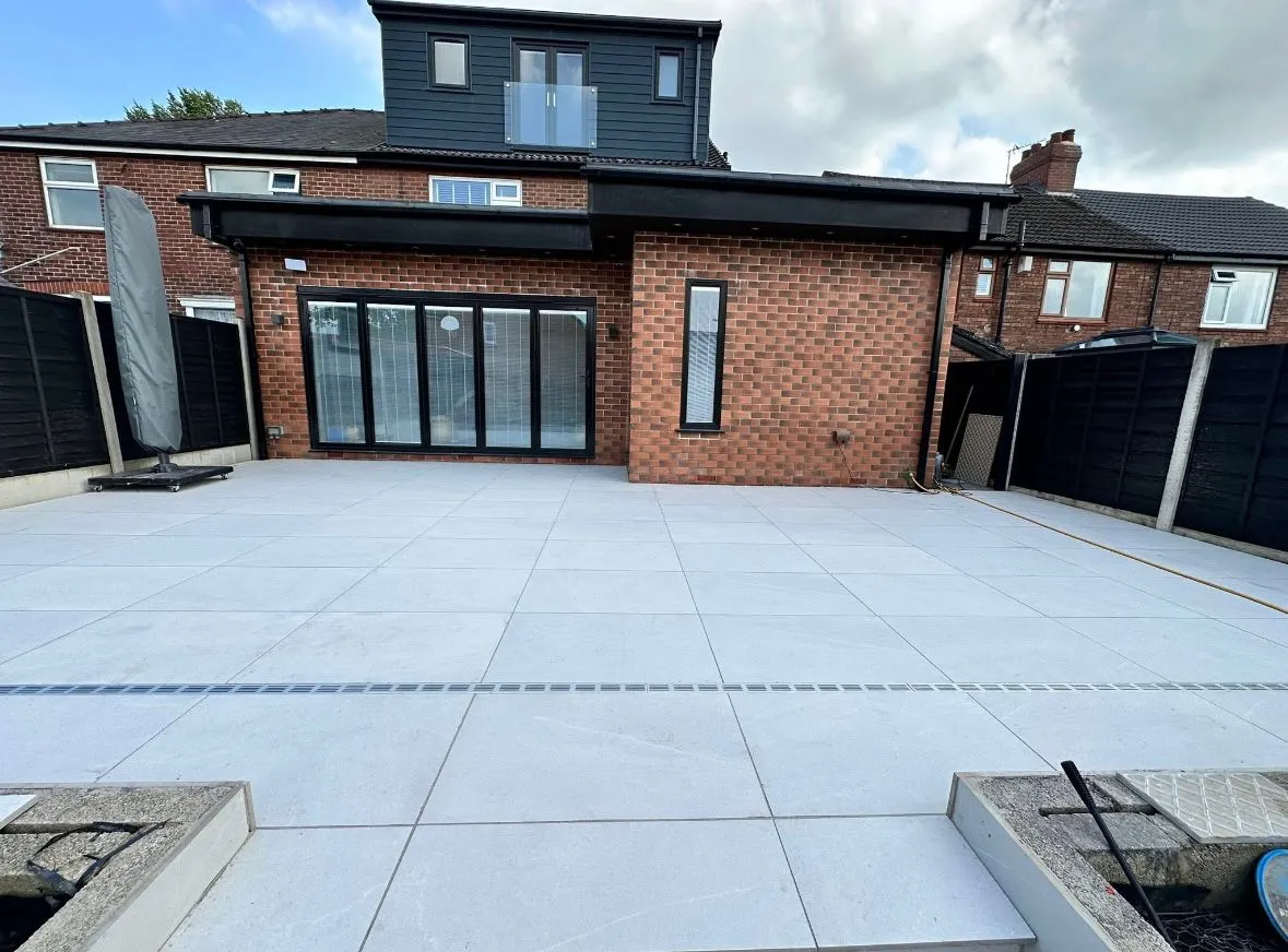 Modern light grey porcelain patio installation in a residential garden