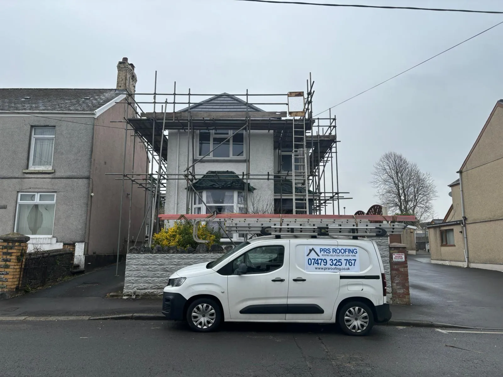PRS Roofing van on-site at a residential property with scaffolding for a new roof installation in Gloucester.