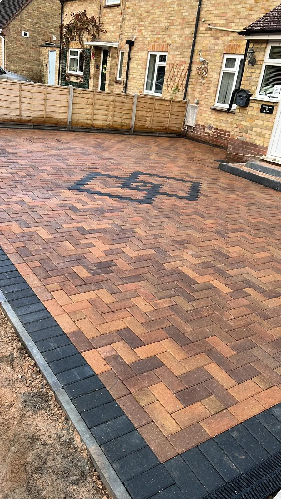 Newly installed block paving driveway with a decorative central pattern and dark border.