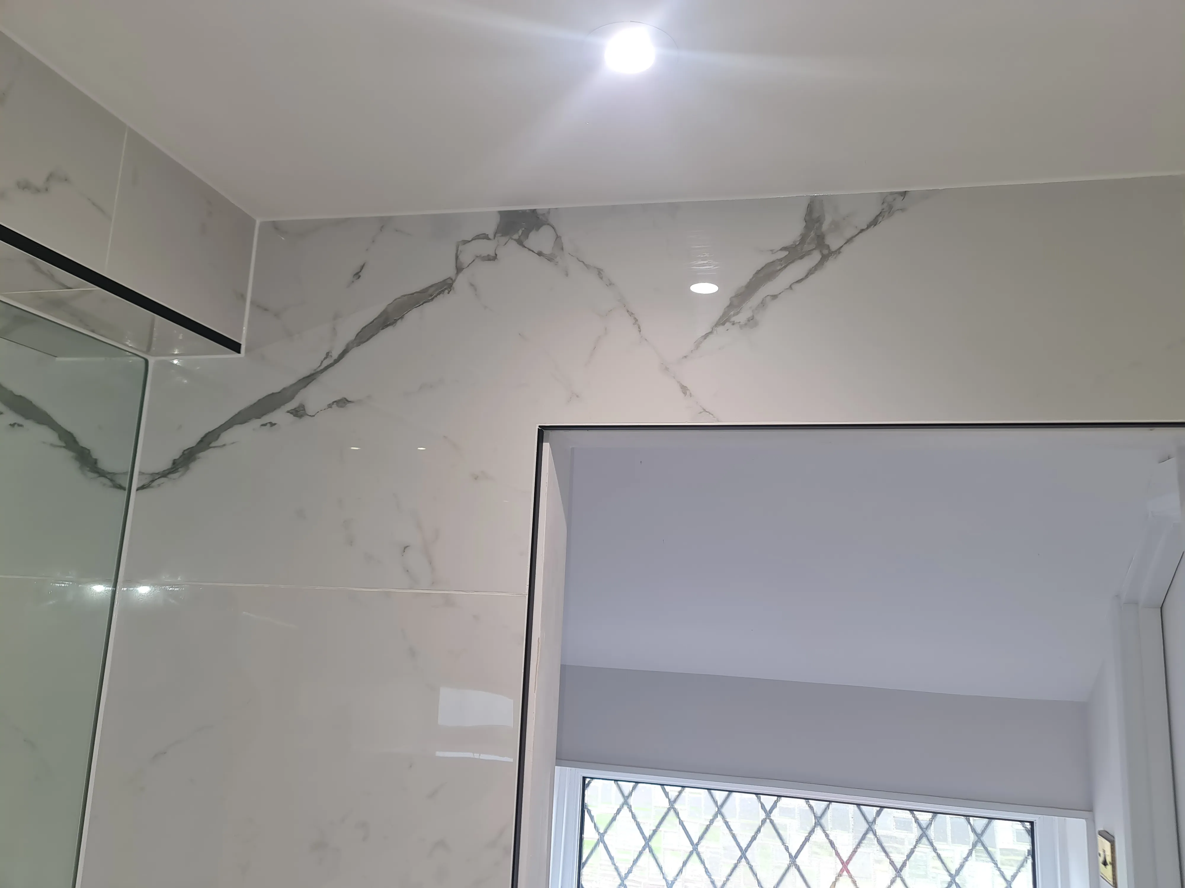 Luxury marble-effect bathroom tiling and professional finish in a bespoke Plymouth home renovation.