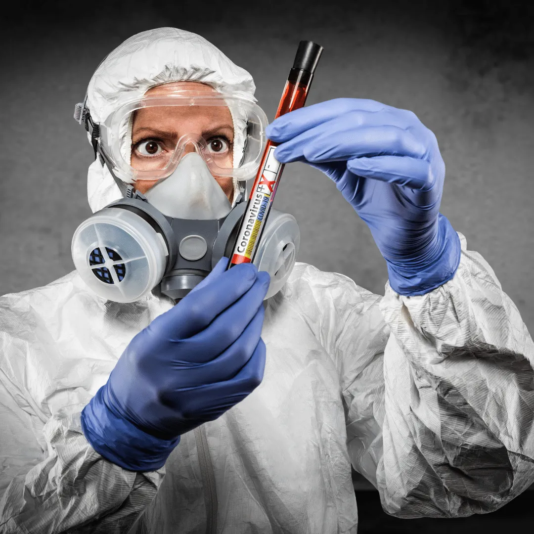 A professional in full protective equipment holding a sample for testing