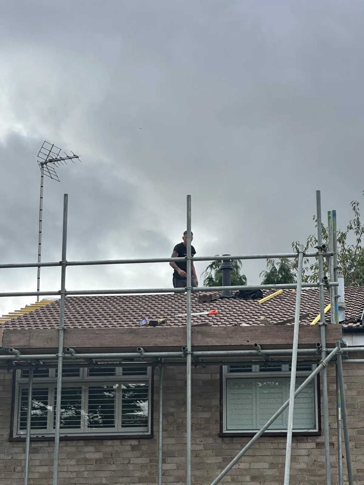 First Choice Roofing Kent roofer performing work on a tiled pitched roof with scaffolding in West Malling