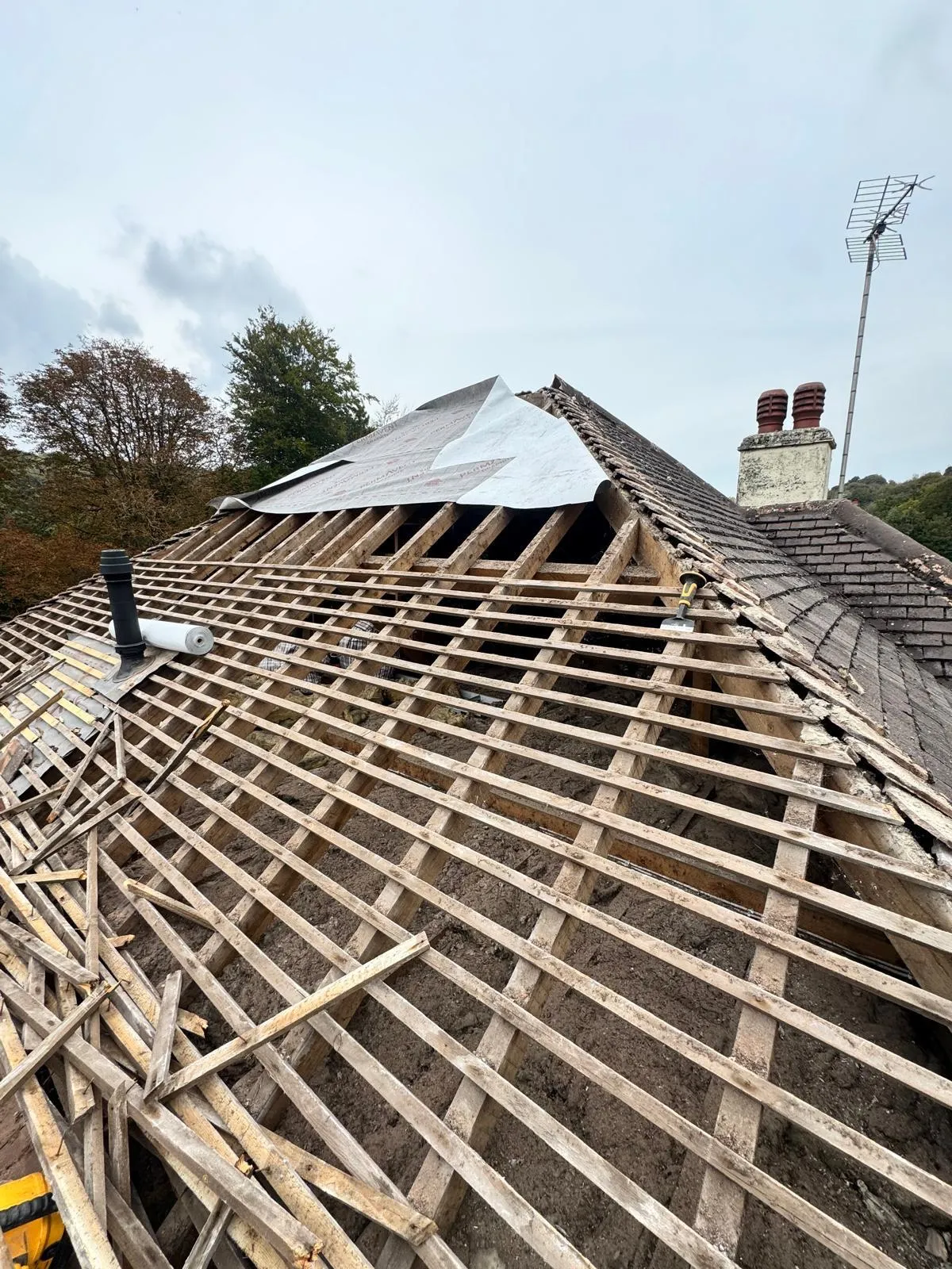 Professional roof replacement in progress in West Malling, showing exposed timber rafters and new roofing felt installation by First Choice Roofing Kent.