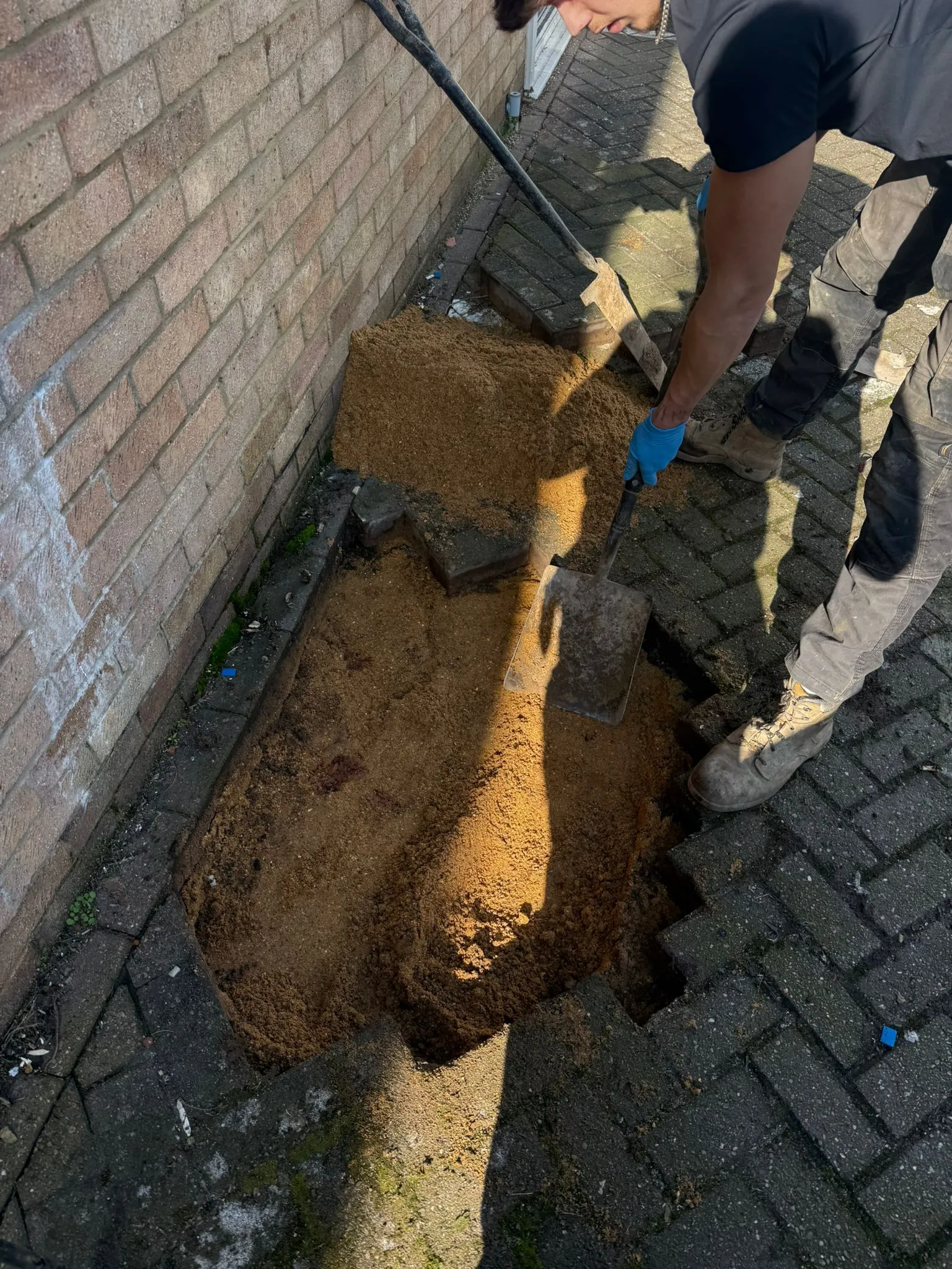 Traditional excavation drain repair on a block-paved driveway in Bournemouth by Drainage South Ltd