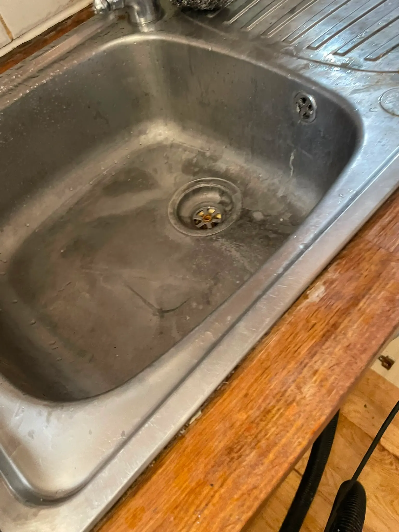 A stainless steel kitchen sink requiring professional unblocking or plumbing repair services