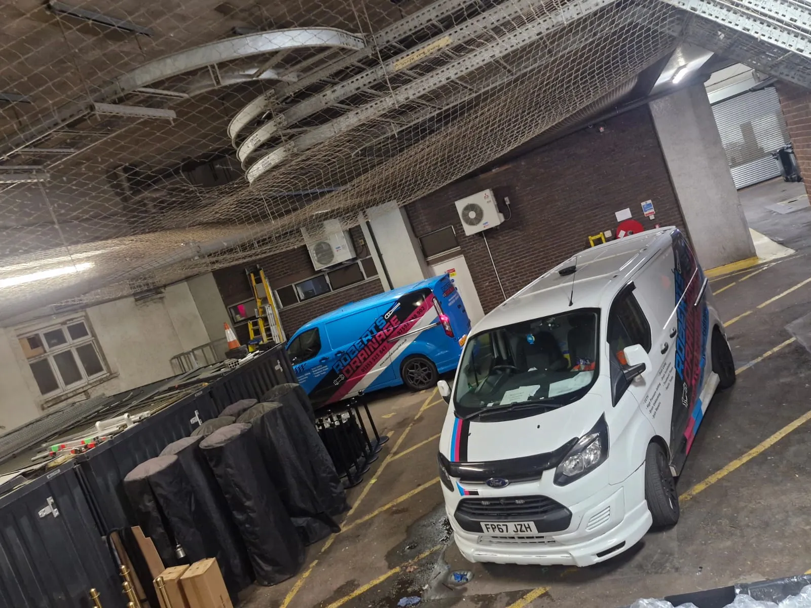 Roberts Drainage Ltd branded service vans at a commercial site