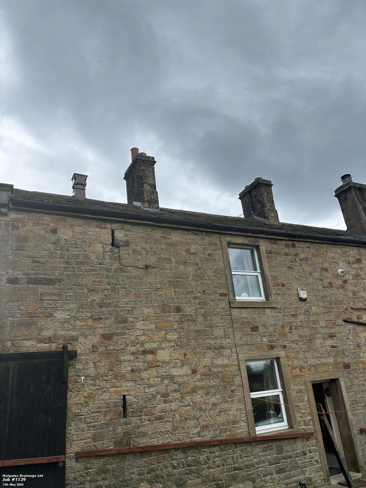 Exterior view of a stone house in Lancashire with chimneys, suitable for bird control and proofing services.