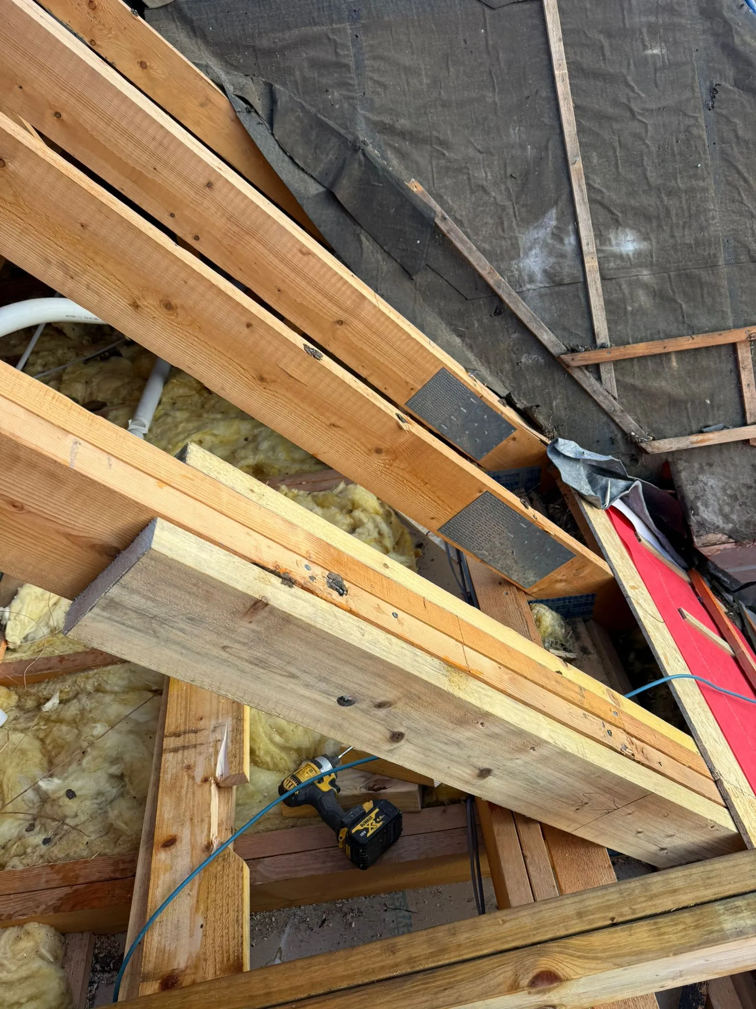 Roof structure with timber rafters, breathable membrane, and insulation being installed for a loft conversion or new roof.
