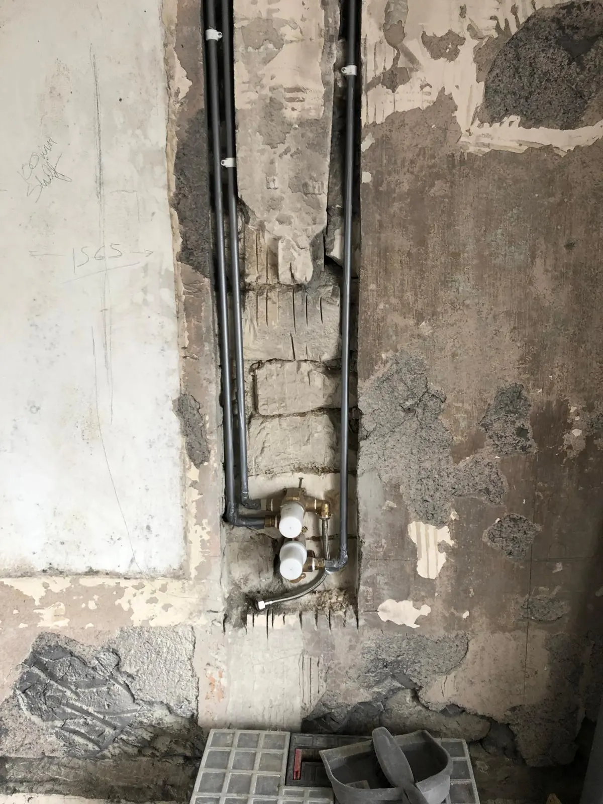 Professional pipe rerouting and shower valve installation within a chased-out wall by BC Plumbing.