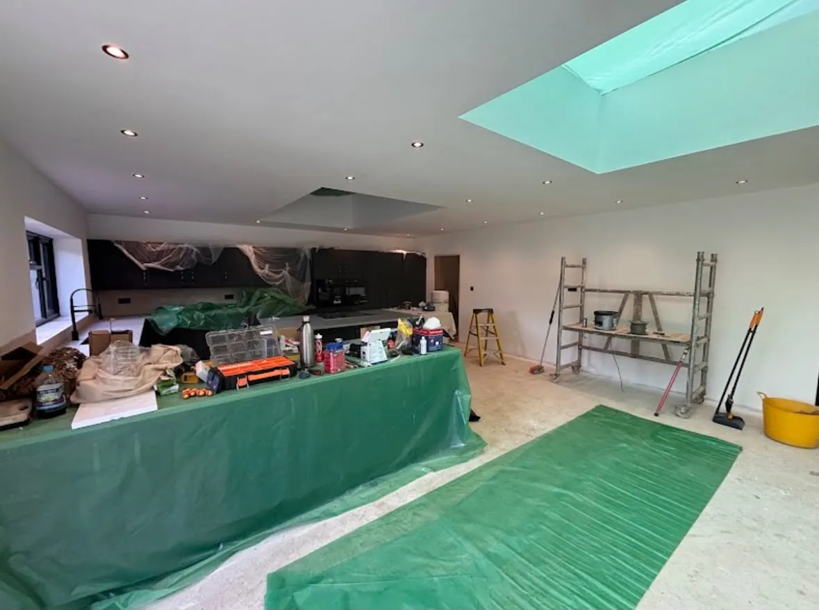 Newly installed ceiling downlights illuminated during a kitchen extension renovation