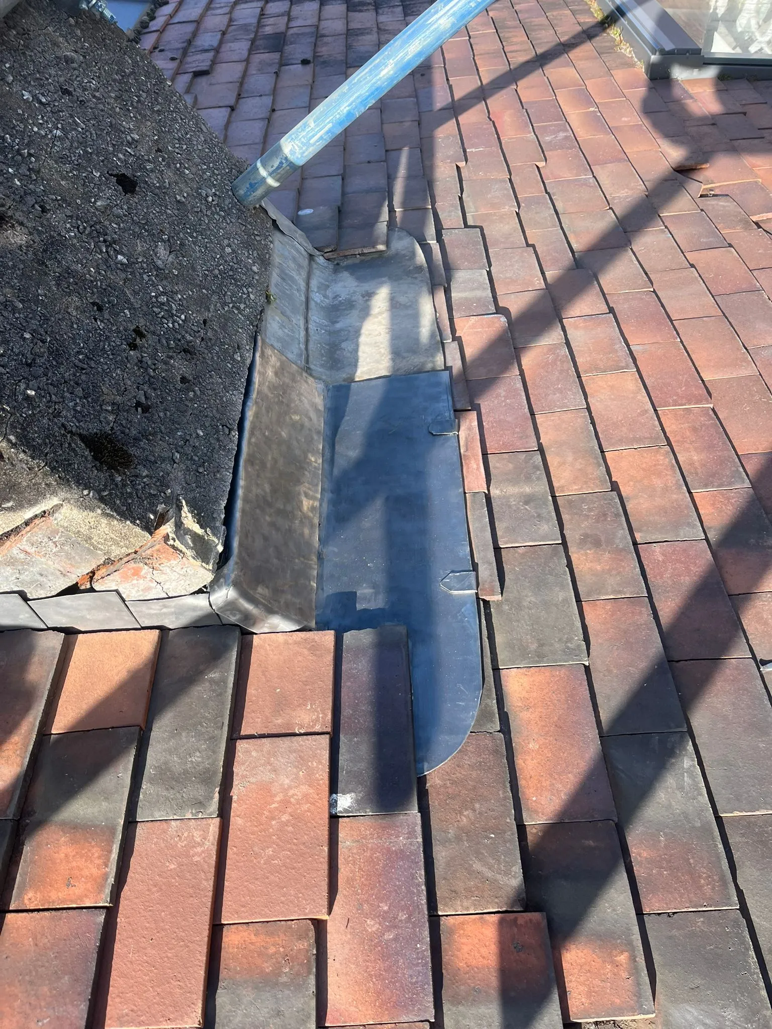 Professional chimney flashing repair on a tiled roof in Gloucestershire.