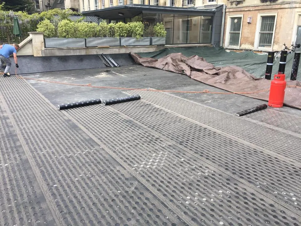 Professional roofer installing a torch-on felt flat roof