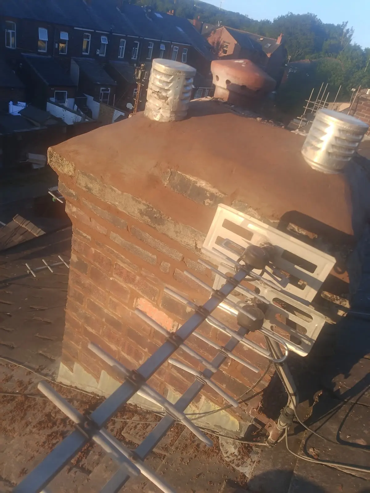 Brick chimney stack and TV aerial on a Burnley roof.