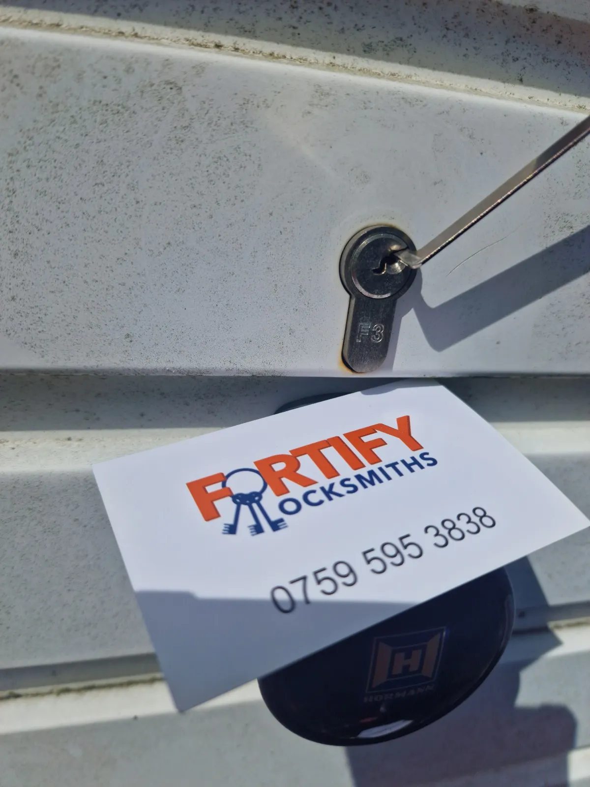 A locksmith picking a door lock for non-destructive entry