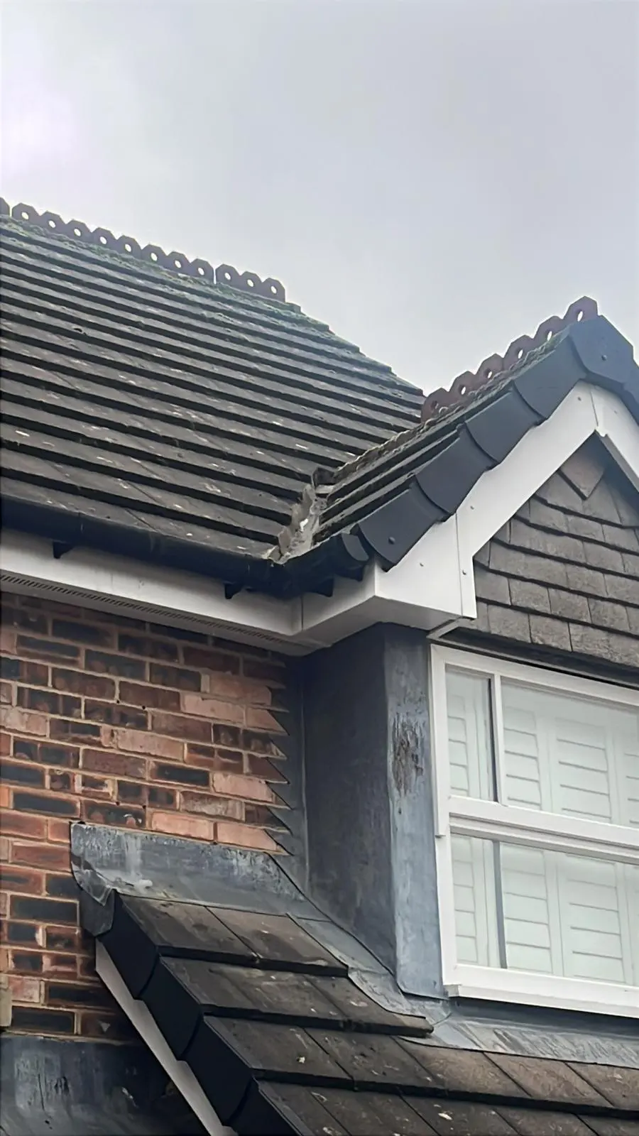 High-quality pitched roof installation showing tiles, white uPVC fascias, soffits, and lead flashing