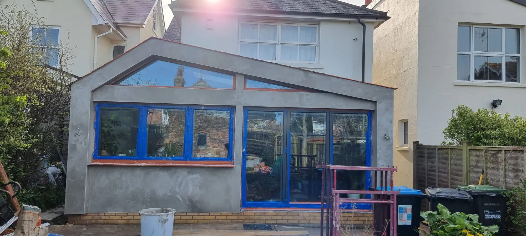 Professional external rendering work being carried out on a house extension in Sussex.
