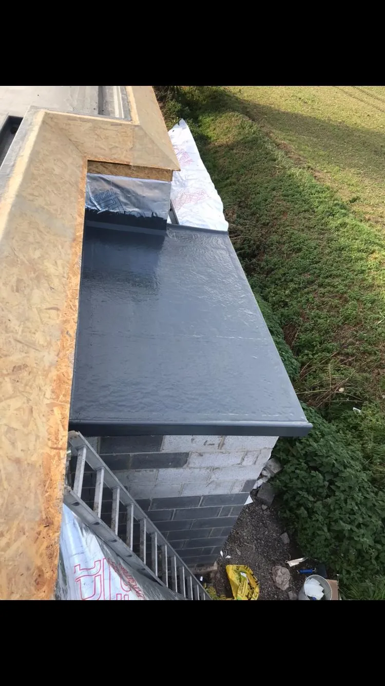 A close-up view of a newly installed grey GRP fibreglass flat roof, showcasing professional workmanship and modern roofing materials.