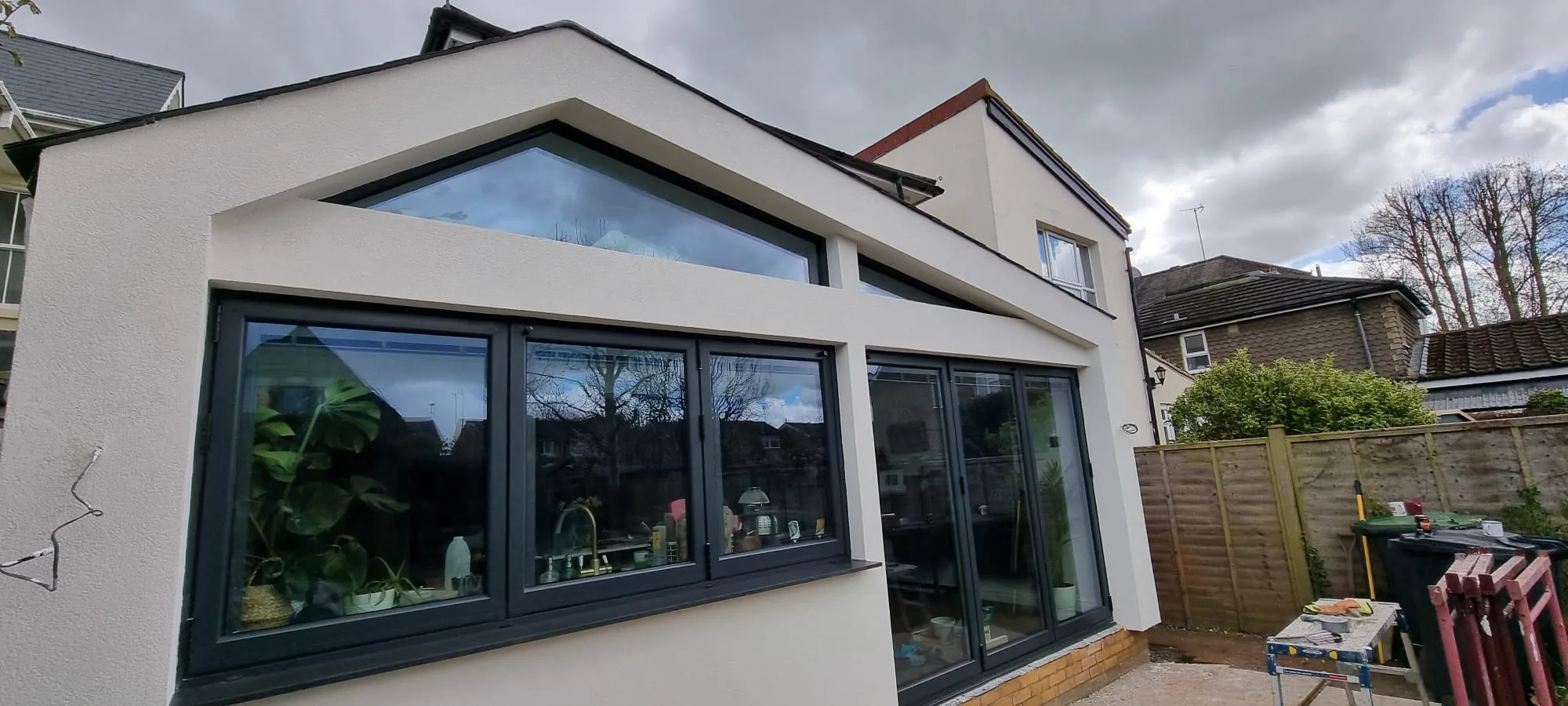 Modern house extension with professional white external rendering and dark grey window frames