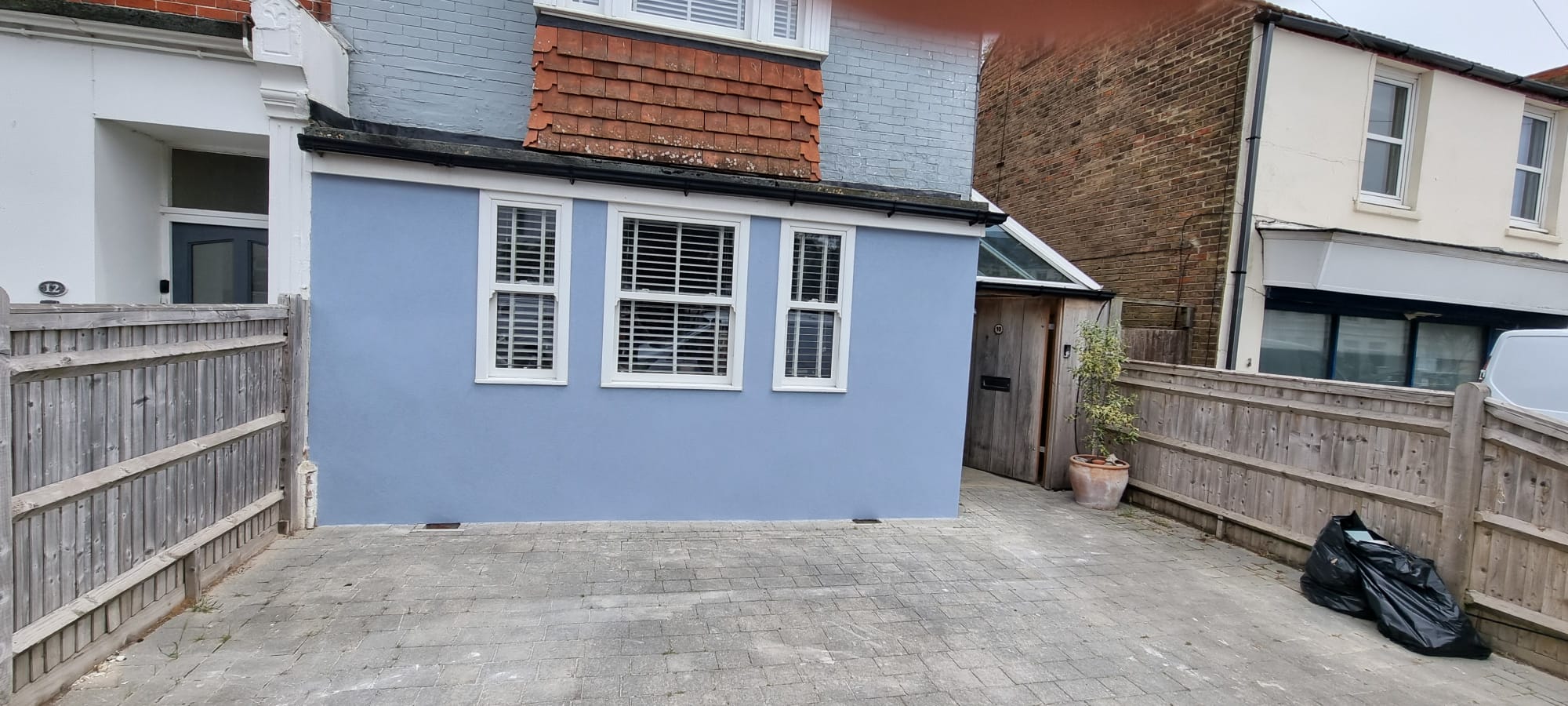 A house with a high-quality blue external rendering finish by Portslade Plastering in Sussex.