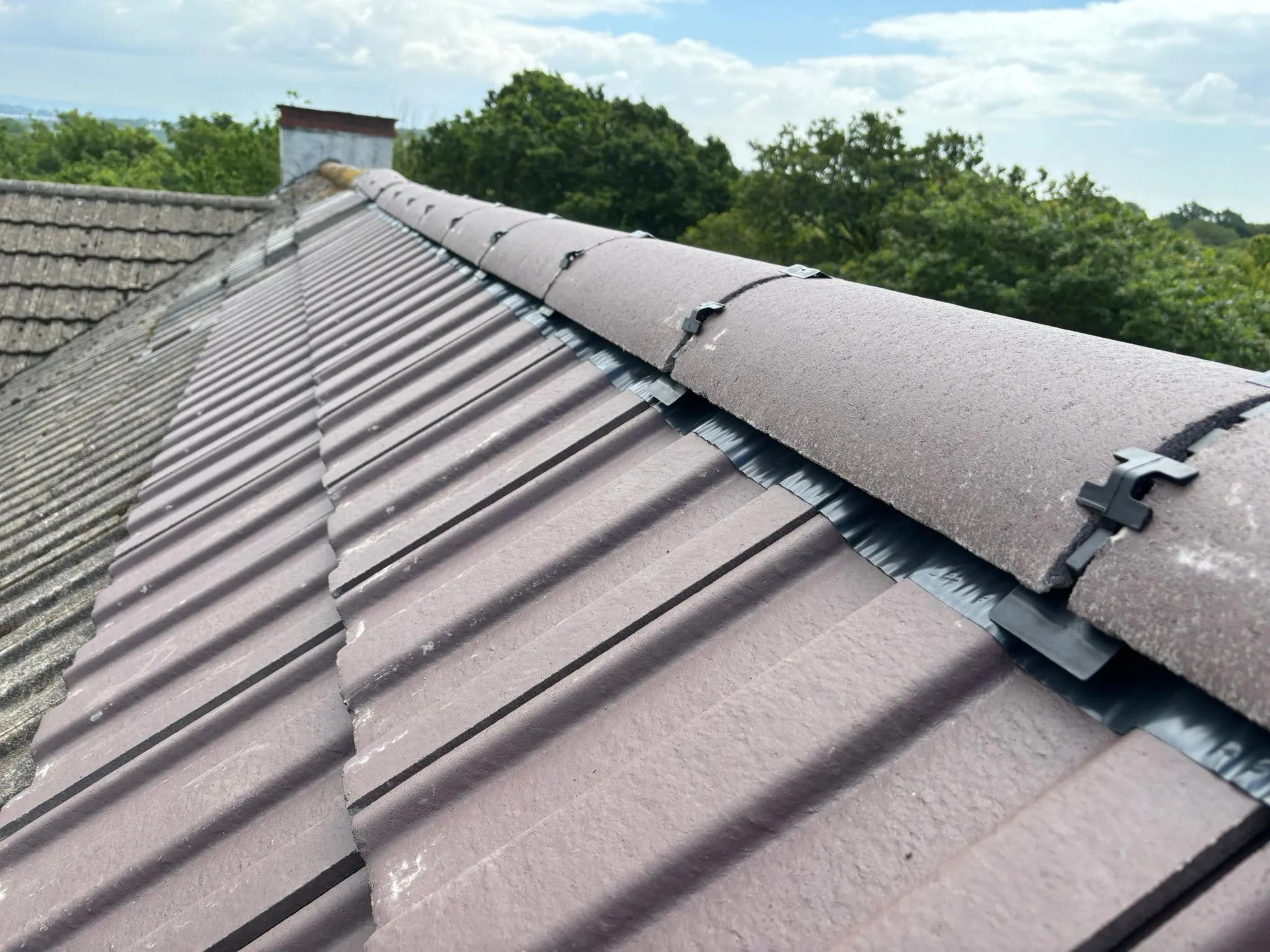 Close-up of a dry ridge system installation on a tiled roof.