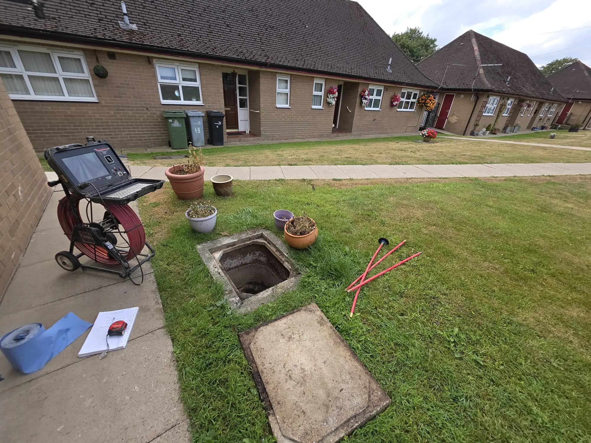 Professional CCTV drain camera and rods ready for inspection outside a residential house