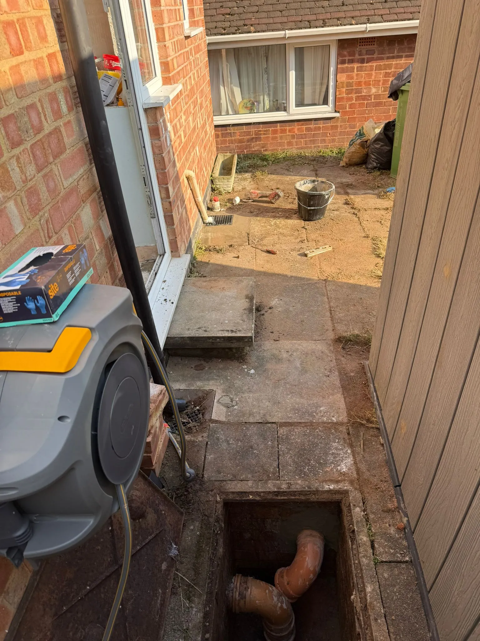 Underground drainage pipework visible in an open manhole during a repair project