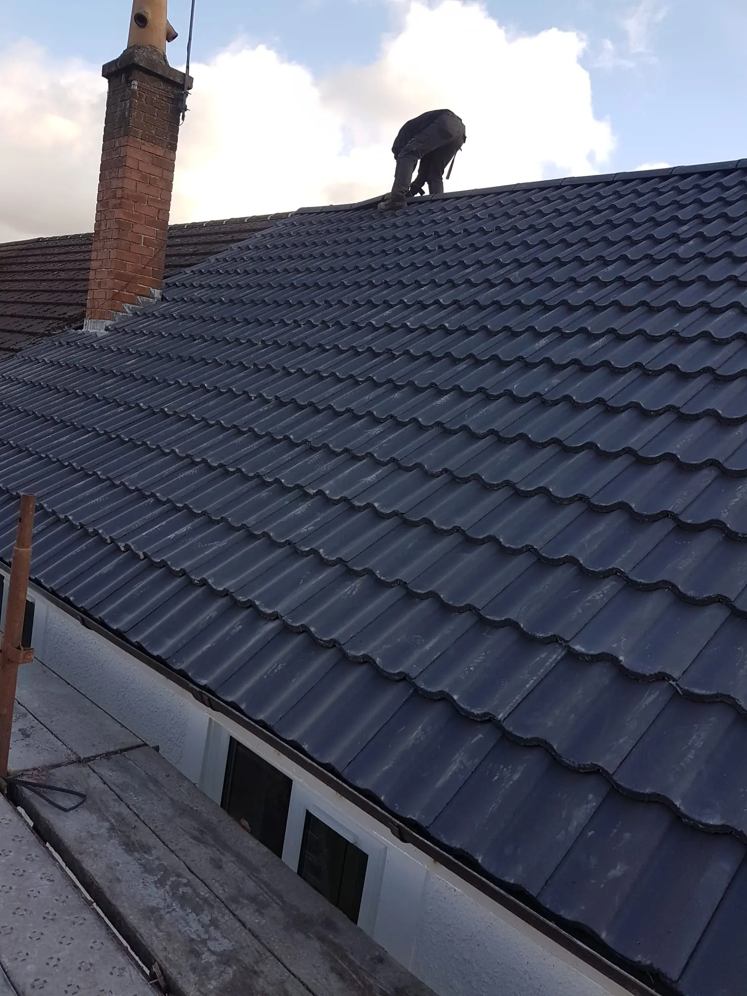 Professional roofer from RM & SON ROOFING & PROPERTY CARE installing a new tiled roof on a property in Fife.