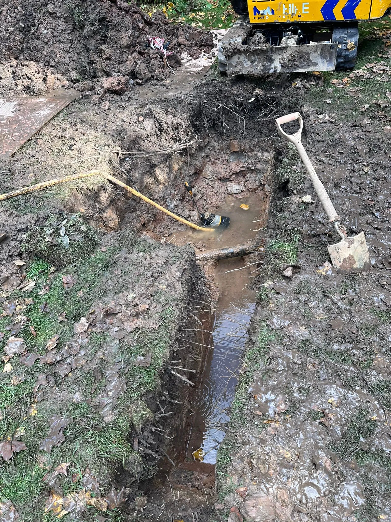 Excavation for drain repair in Macclesfield showing a trench and pump