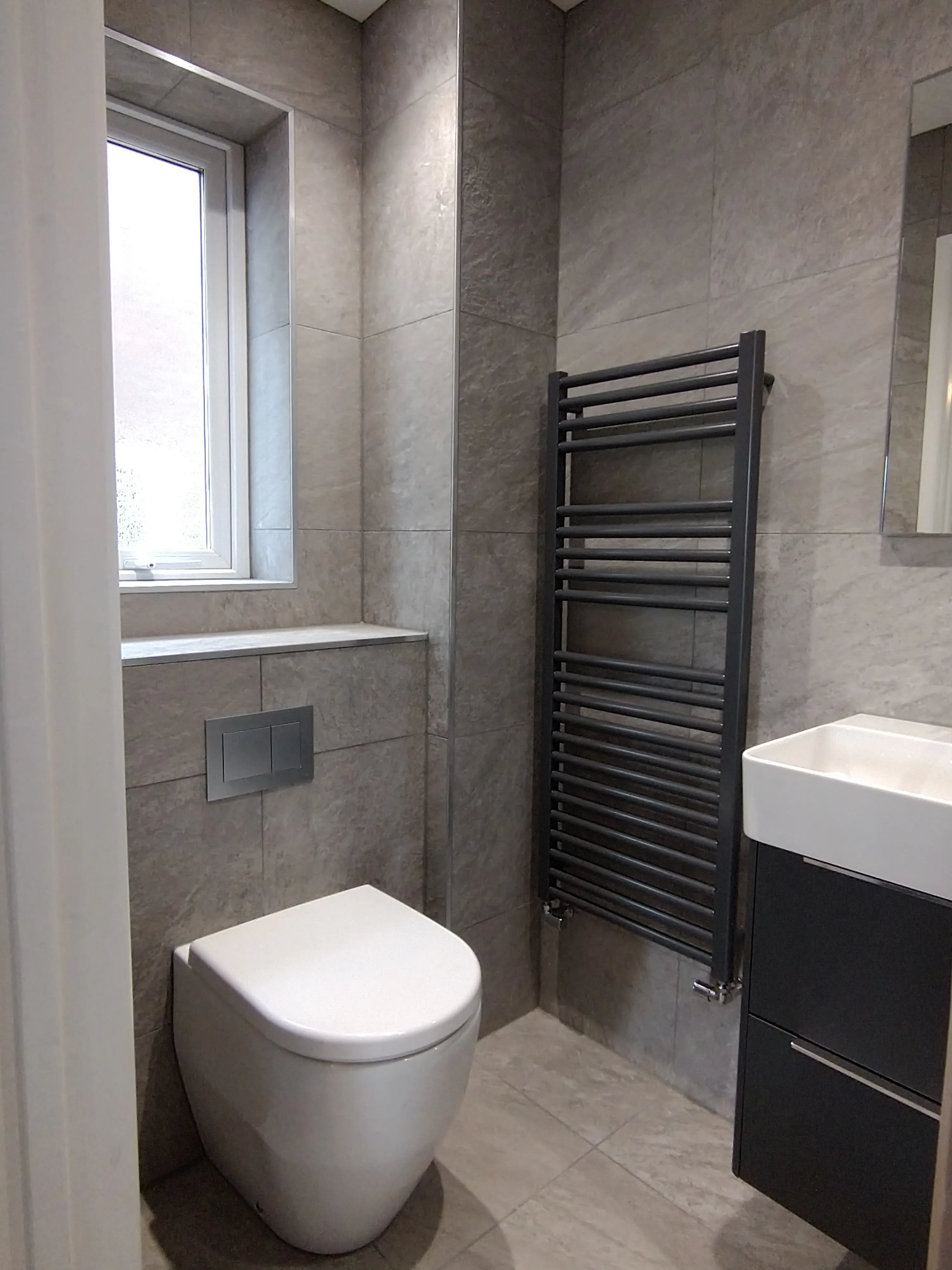Luxury bespoke cloakroom renovation in Plymouth featuring modern grey tiling and high-end fixtures by Sands & Vossen.