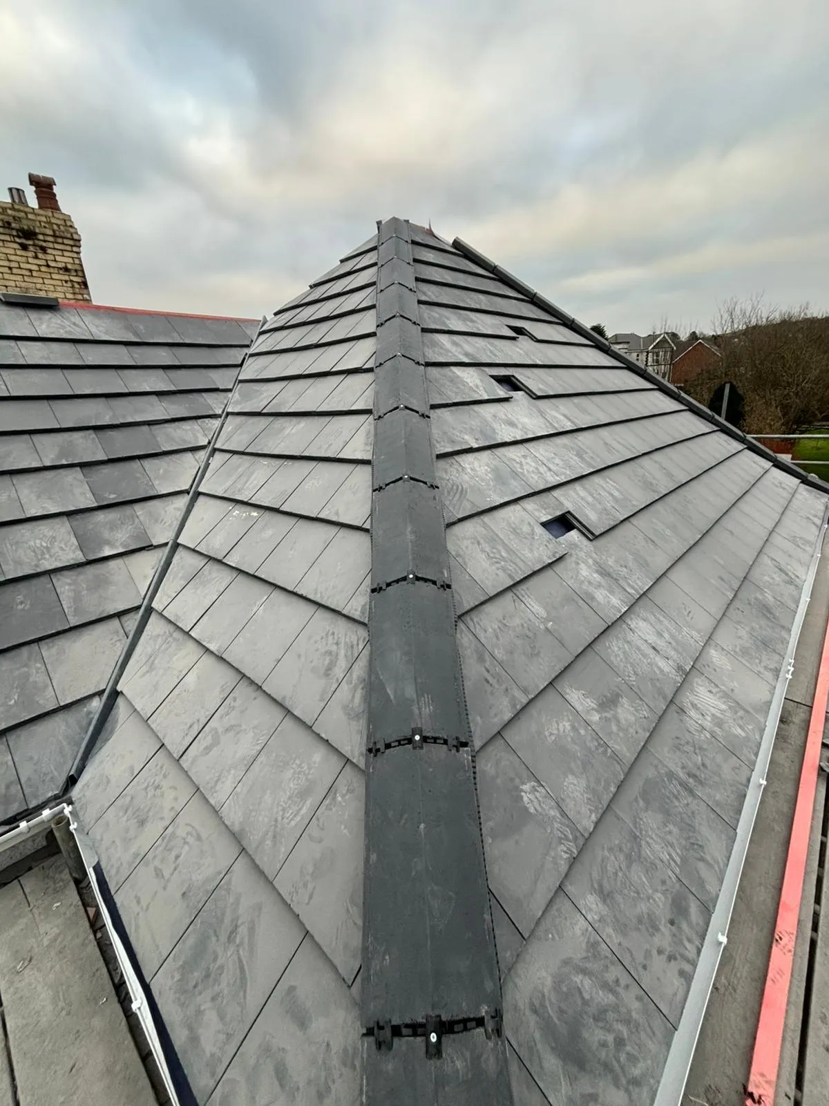 Newly installed grey slate roof with a dry ridge system by PRS Roofing in Gloucestershire.