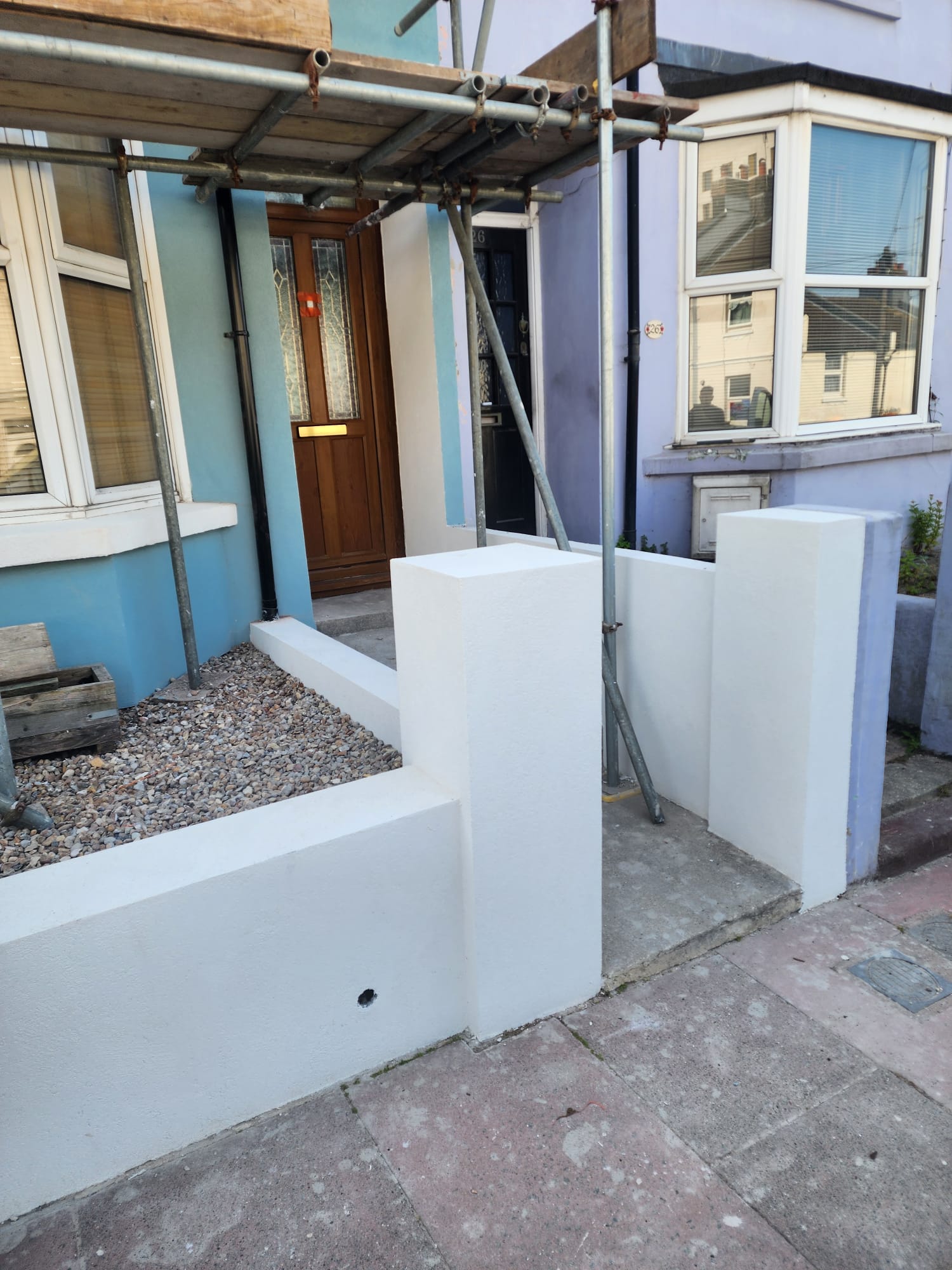 Clean white external rendering on a front garden wall and pillars by Portslade Plastering.
