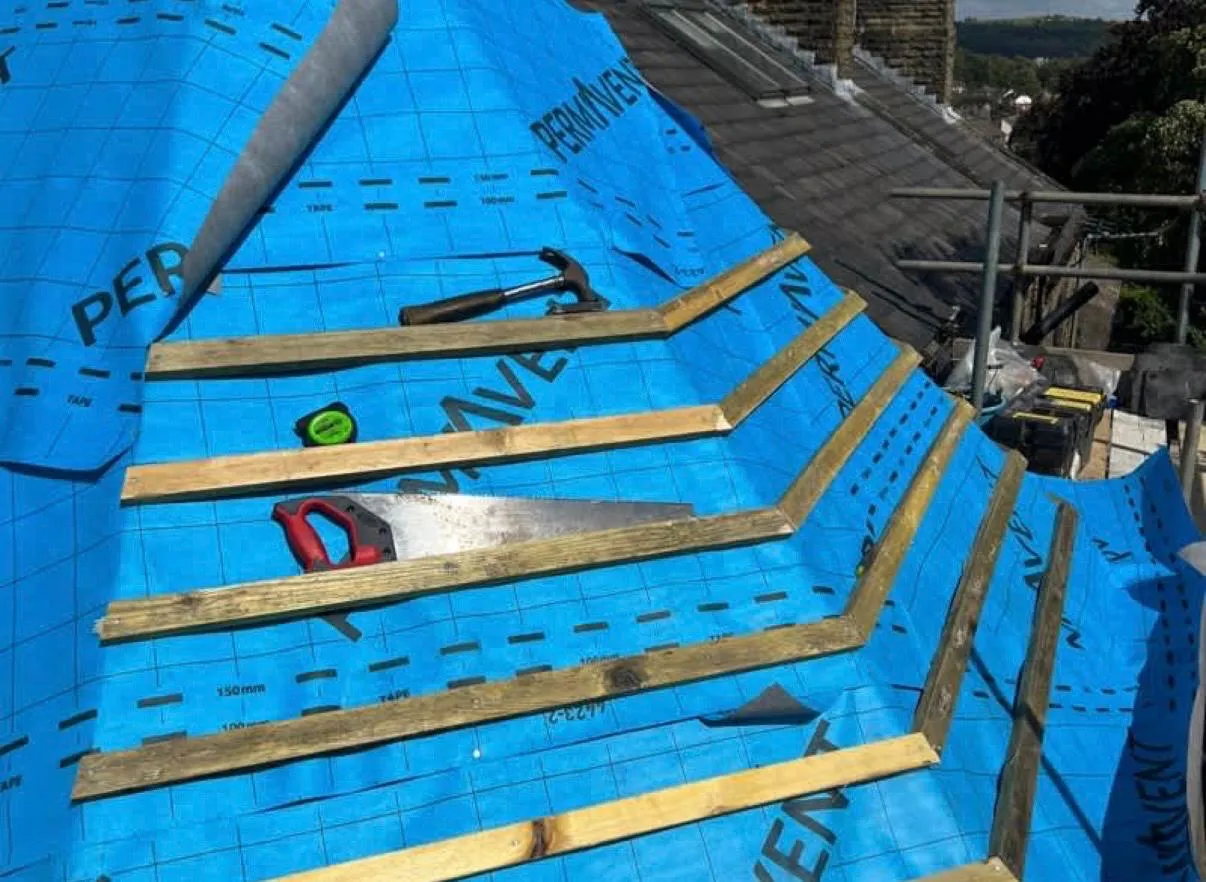 New roof installation in progress showing blue membrane and wooden battens on a property in Holmfirth.