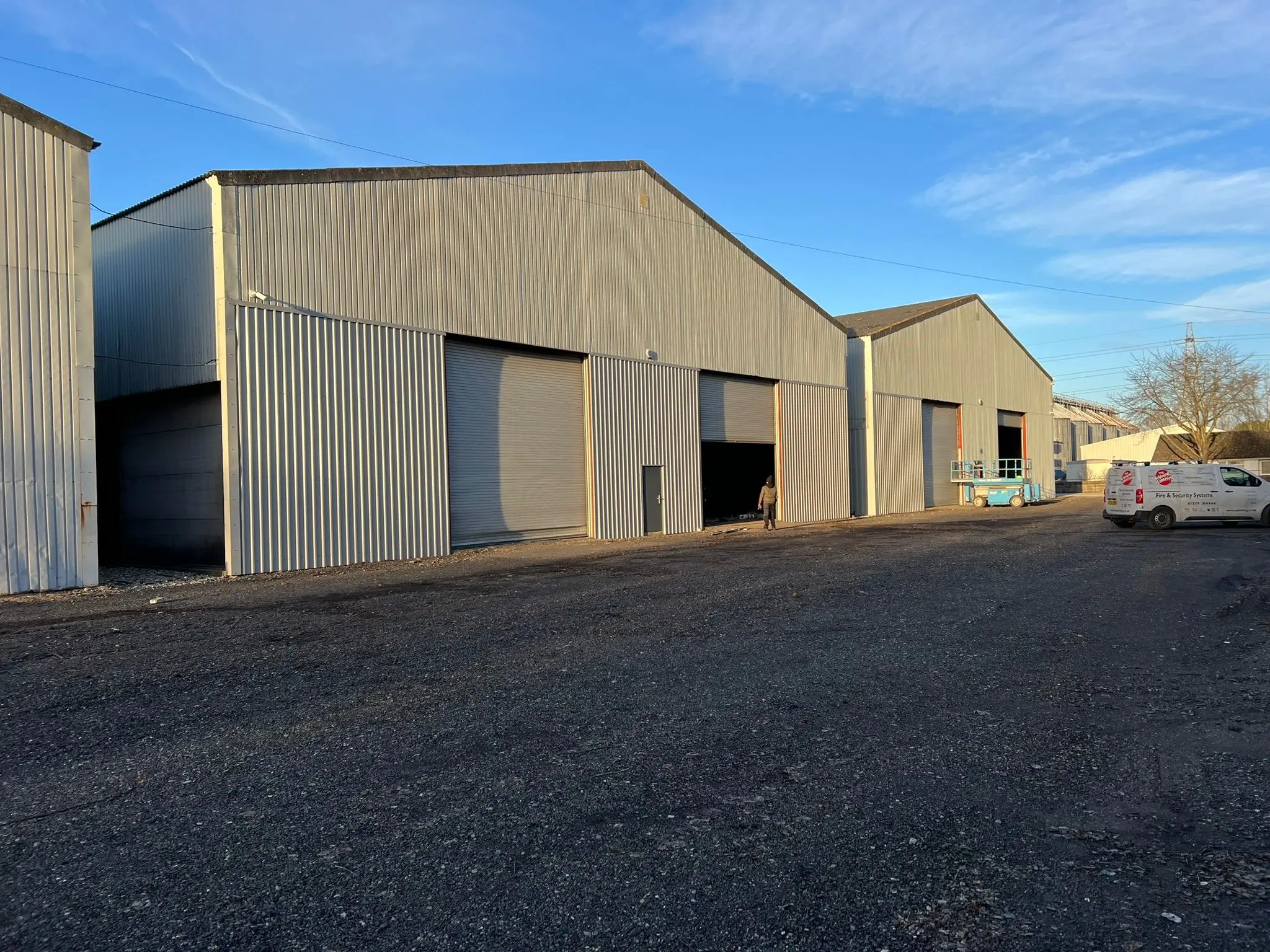 A row of newly constructed steel frame industrial units on a commercial estate featuring metal cladding and roller shutter doors.