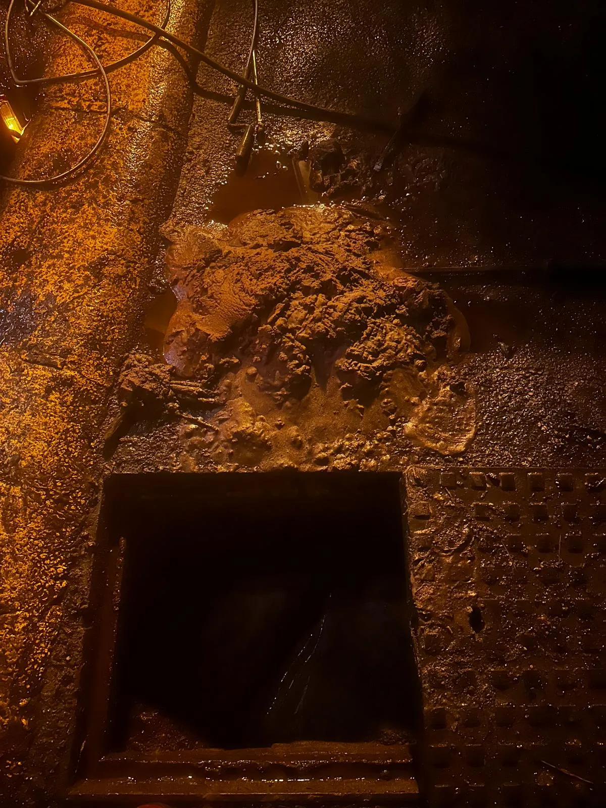 A picture of a major drain blockage overflowing from an access point.