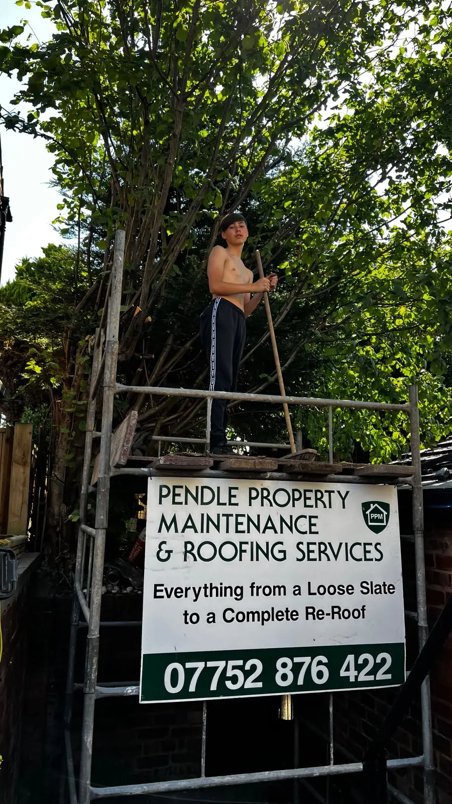 Pendle Property Maintenance & Roofing Services sign attached to scaffolding in a garden setting
