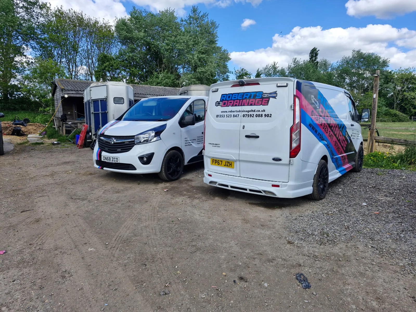 Roberts Drainage Ltd service vans parked outdoors, showcasing the company's professional fleet in Cambridgeshire.