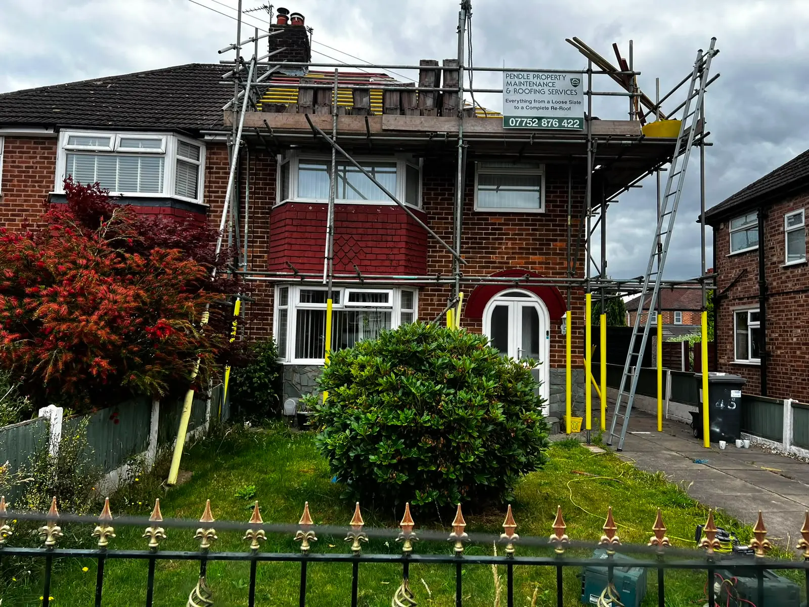 Brick house with scaffolding for roofing services in Burnley
