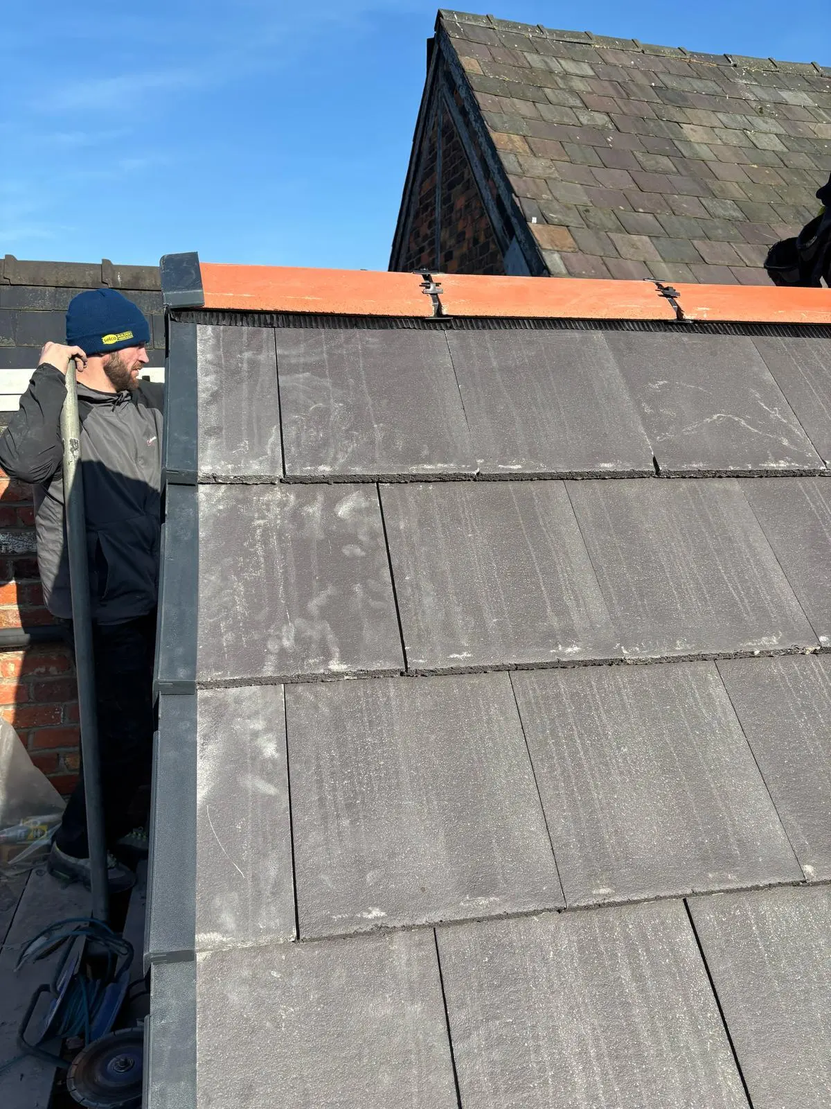 Local roofer installing a dry ridge and dry verge system on a new tiled roof