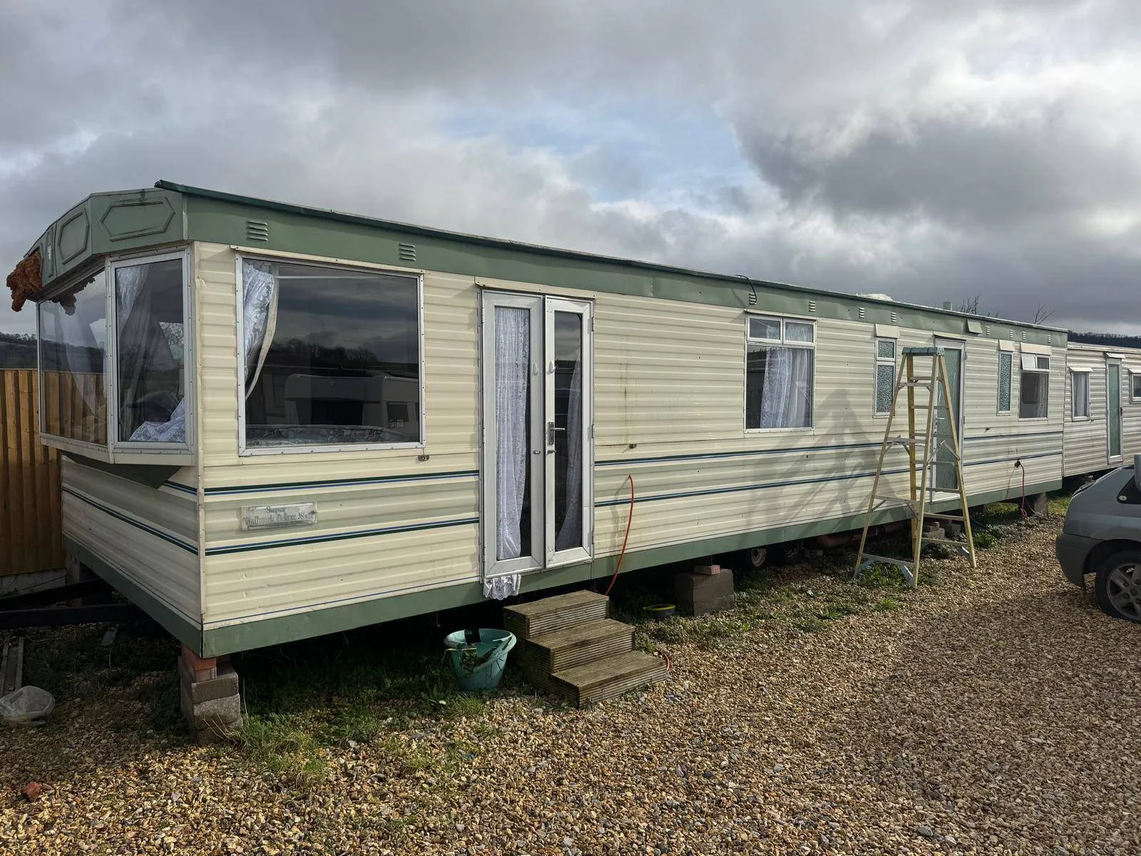 Static caravan exterior sited on gravel blocks prior to clearance
