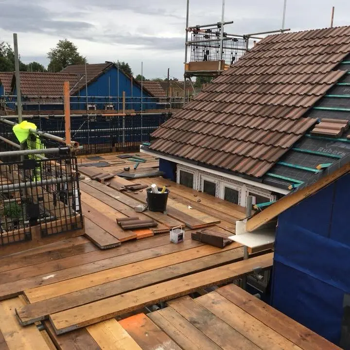 Amac Roofing specialists carrying out a pitched roof replacement, installing new battens, breathable membrane, and brown concrete roof tiles.