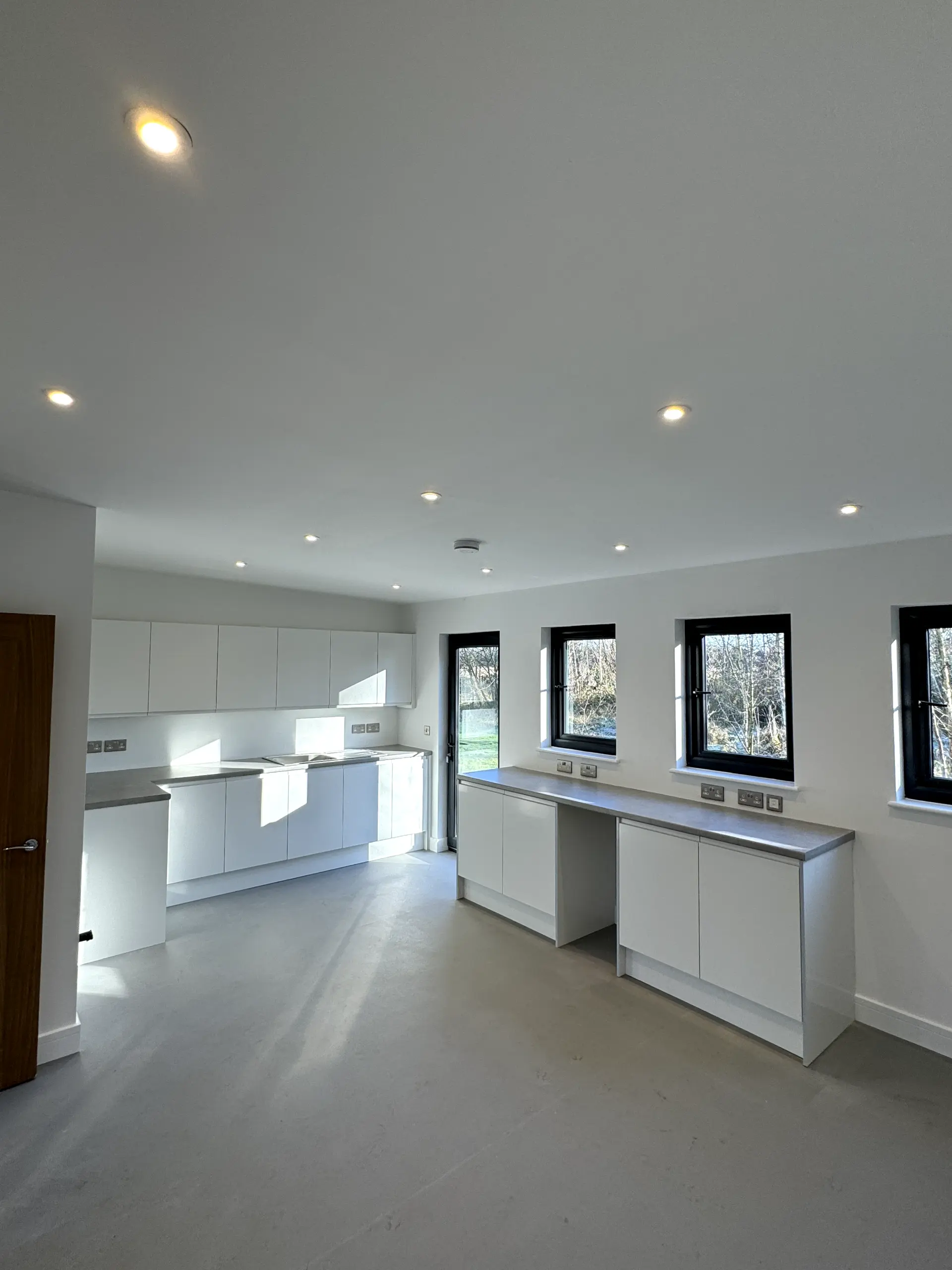 Professional kitchen electrical rewire featuring energy-efficient LED spotlight upgrades and new wall sockets installed by JH Electrical Contractors Ltd in Warrington.