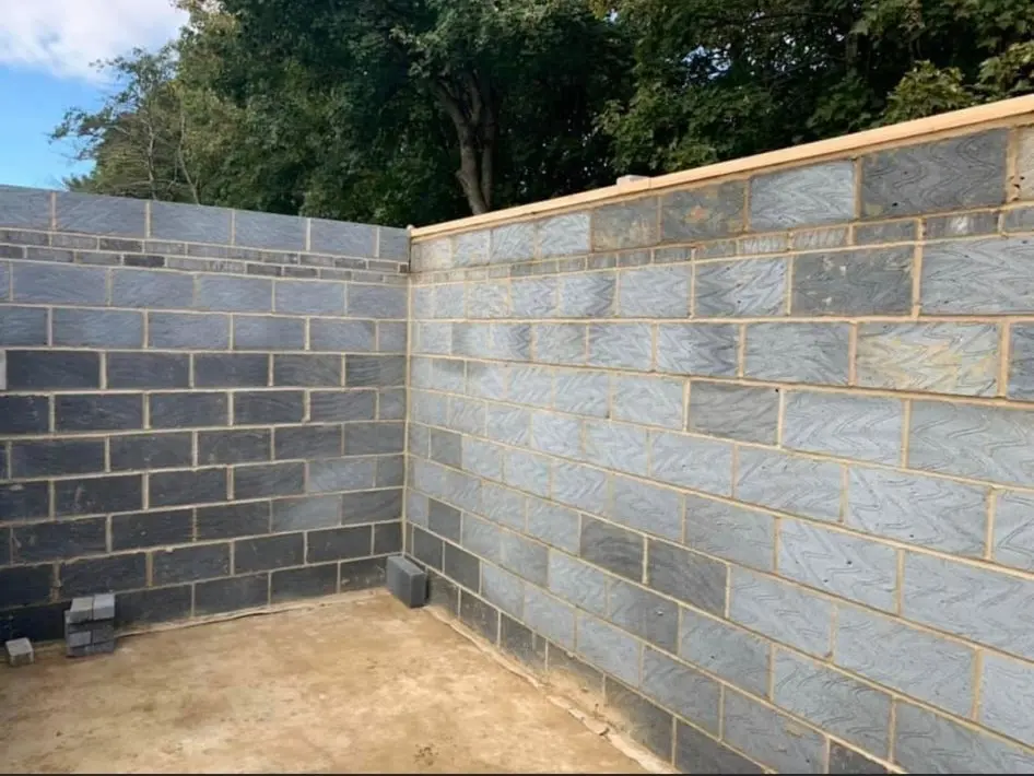 Freshly laid grey blockwork corner wall built by professional bricklayers in an outdoor setting