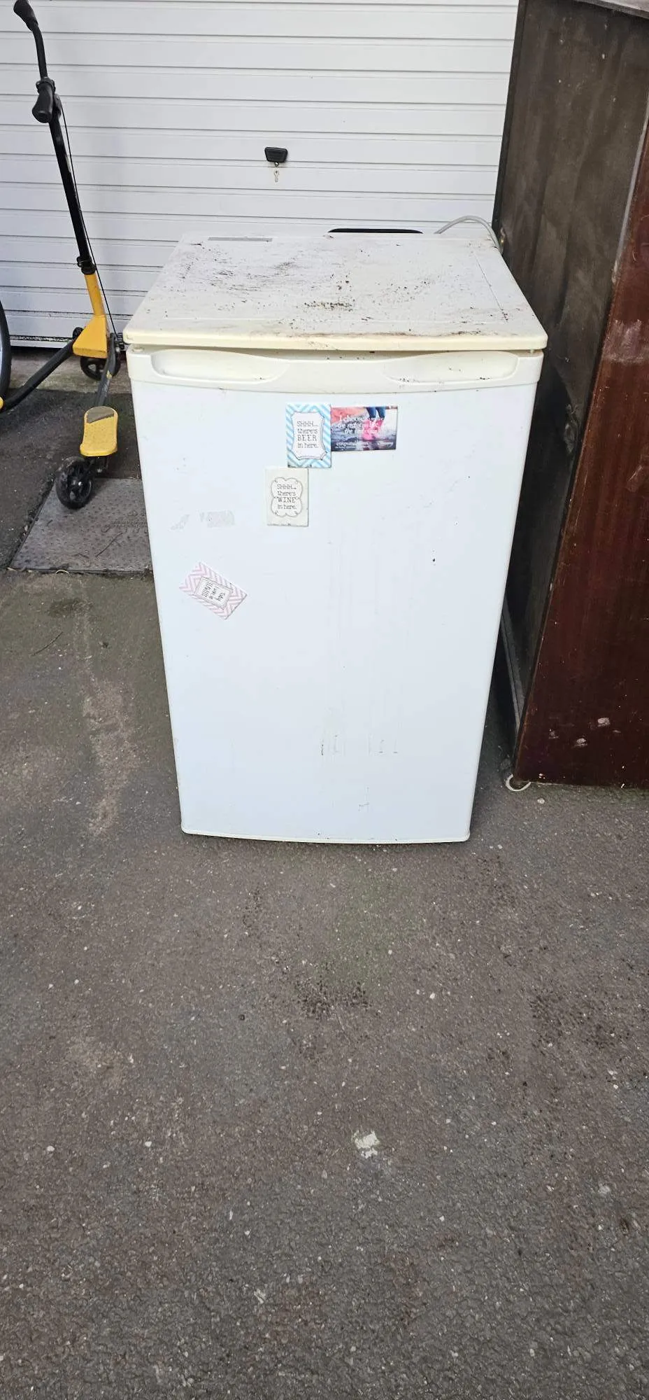 An old white domestic fridge waiting outside for licensed white goods disposal in Birmingham