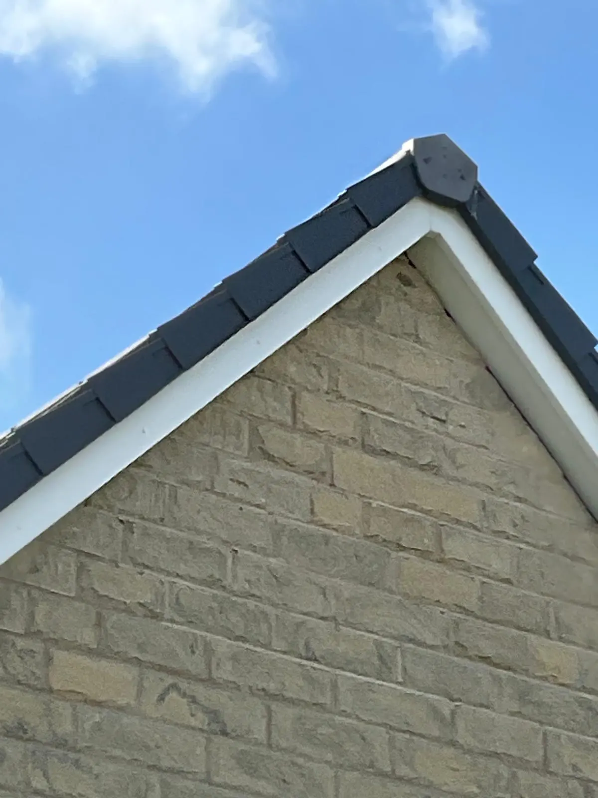 Newly installed white uPVC fascias and soffits on a brick house gable